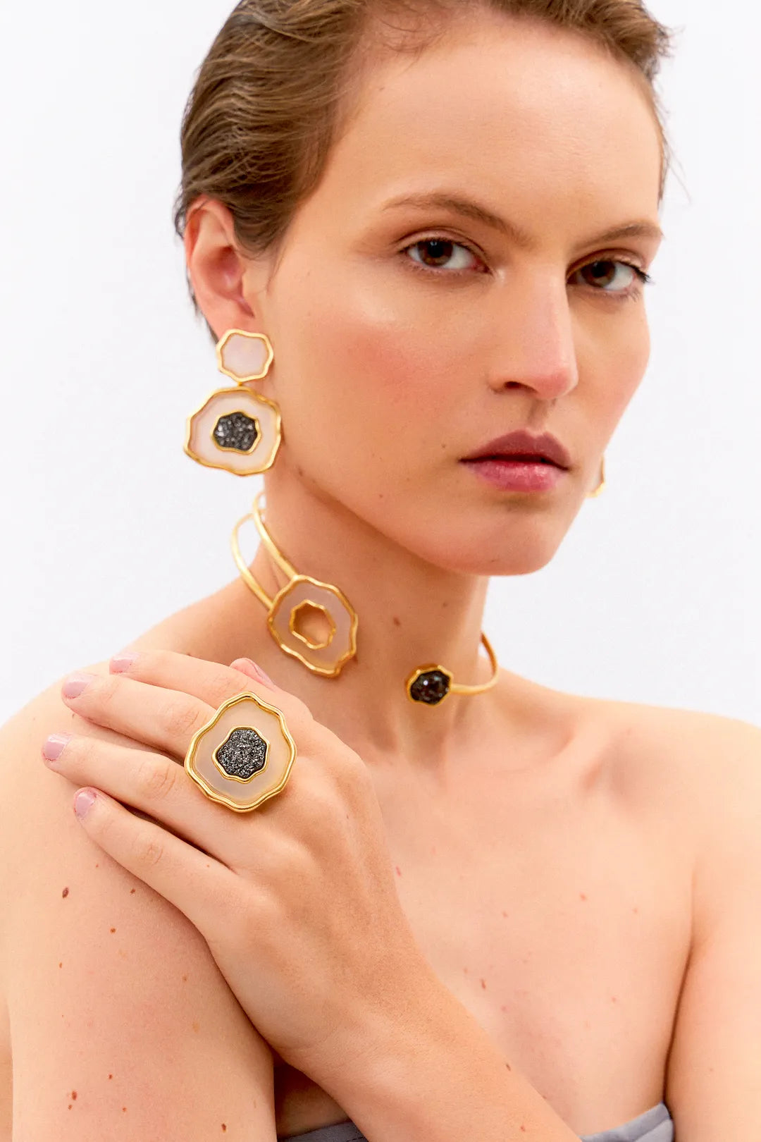 Esta joia combina o contraste de cores clássico com forte simbologia, sendo adornada com Ágata Branca, que promove a paz e a clareza, e Drusa Negra, que atrai energia positiva e proteção. Use este anel em Banho de Ouro 18K para celebrar o seu próprio florescer com elegância.