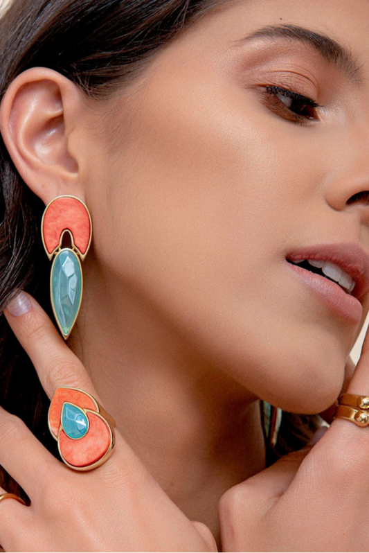 Esta joia combina cores que remetem ao sol e ao céu com o luxo do Banho de Ouro 18K. O anel é adornado com o Feldspato Laranja, que traz energia e vitalidade, e a Ágata Azul Céu, que oferece serenidade e paz interior.