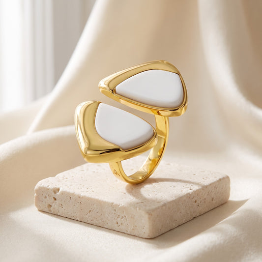 Anel Ailes Porcelana Branca banhado a ouro 18k em vista 3/4 sobre travertino | Aimer Joias