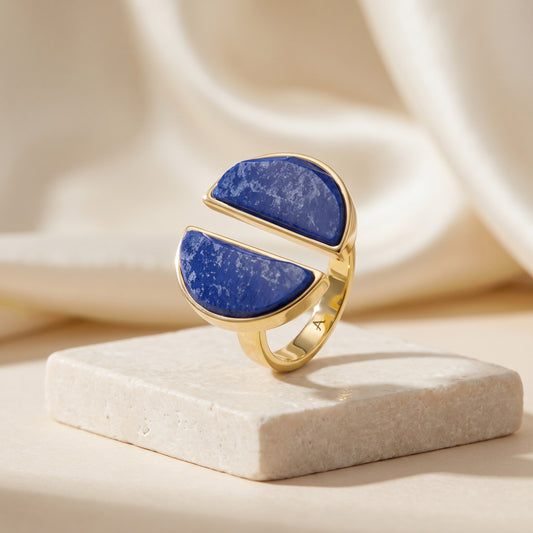 Anel Arco Feldspato Azul Anil banhado a ouro 18k em vista 3/4 sobre travertino | Aimer Joias