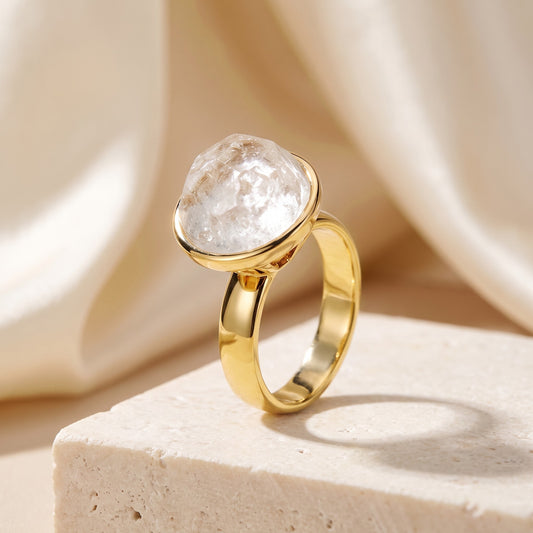 Anel Classic Cristal de Rocha banhado a ouro 18k em vista 3/4 sobre bloco de travertino | Aimer Joias
