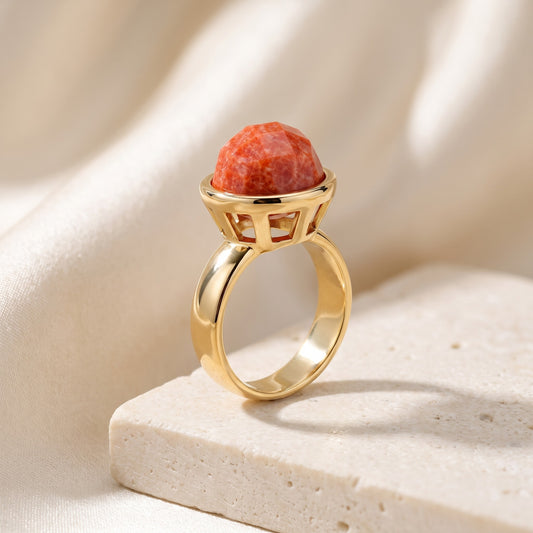 Anel Classic Feldspato Laranja banhado a ouro 18k em vista 3/4 sobre bloco de travertino | Aimer Joias