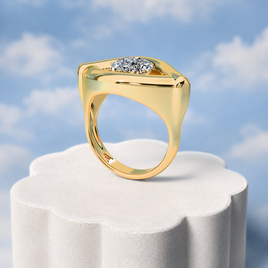Anel Despertar - Drusa Metalizada: sobre pedestal de gesso em forma de nuvem, fundo de céu azul-claro. Semijoia banhada a ouro 18k, coleção Supernova, Aimer Joias