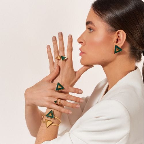 O Conjunto Atena - Ágata Verde é um trio de joias banhadas em Ouro 18K que celebra o equilíbrio, a força e o autoconhecimento. Composto pelo Anel Imperium, Bracelete Atena e Brinco Archi, este conjunto é adornado com a Ágata Verde, uma pedra natural associada à cura, regeneração emocional e prosperidade.