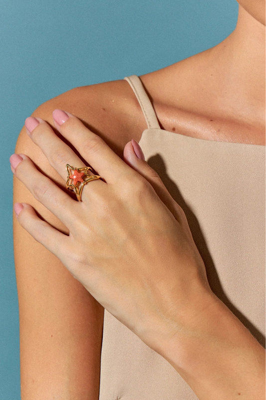 O Anel Brisa com Feldspato Laranja em Banho de Ouro 18K é uma joia delicada, com uma estrela central em meio a uma onda fluida que a sustenta. A tonalidade vibrante do Feldspato Laranja é realçada pelo luxo do ouro, criando um visual sofisticado e cheio de energia.