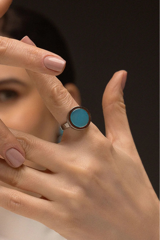 O Anel Eterno - Ágata Azul Céu, da Coleção Singular, une a serenidade das águas à sofisticação do acabamento escuro. A Ágata Azul Céu é reconhecida por promover calma, clareza mental e harmonia nas emoções, criando um contraste moderno e impactante com o metal escuro. Banhado a Ródio Negro, este anel de design contínuo e imponente destaca a suavidade da pedra, sendo a peça ideal para mulheres que buscam um acessório contemporâneo que transmita paz interior com uma personalidade forte.