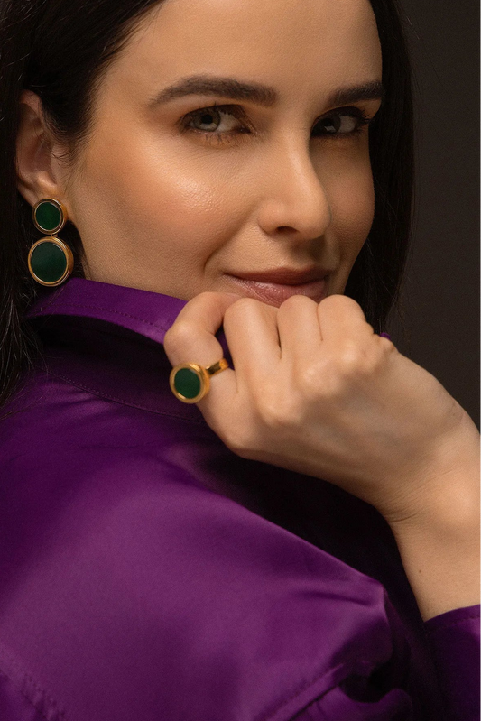 O Anel Eterno - Ágata Verde, da Coleção Singular, é uma joia que emana vitalidade e equilíbrio. A Ágata Verde é conhecida por ser a pedra da saúde, esperança e cura emocional, auxiliando na autoconfiança e no bem-estar físico. Banhado a Ouro 18K, este anel de design contínuo e imponente destaca a cor vibrante e a elegância atemporal da pedra, sendo a escolha ideal para quem busca uma conexão com a natureza e harmonia interna.