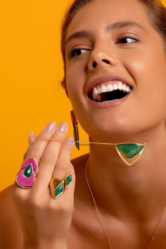 Esta joia combina cores que celebram a natureza e a feminilidade, emolduradas pelo luxo do Banho de Ouro 18K. O anel é adornado com a Ágata Verde, que promove equilíbrio e cura, e o Feldspato Rosa Pink, que adiciona um toque vibrante e romântico.