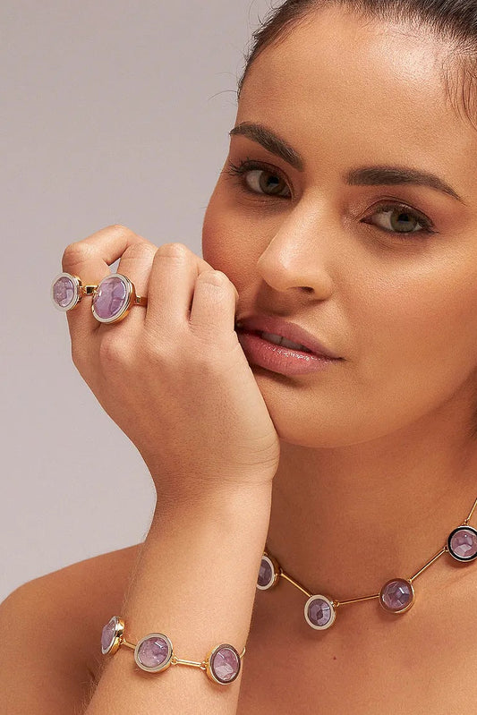 O Anel Único - Ametista, da Coleção Singular, é uma joia de serenidade e poder espiritual. A Ametista é amplamente reconhecida como a pedra da sabedoria, equilíbrio e transmutação de energias negativas em positivas. Banhado a Ouro 18K e com um design imponente, este anel destaca a beleza profunda do violeta, sendo o acessório ideal para a mulher que busca elegância aliada à paz interior e proteção.