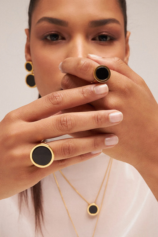 O Anel Único - Obsidiana Negra, da Coleção Singular, é uma joia de grande força e proteção. A Obsidiana Negra é uma poderosa pedra de proteção energética, purificação e aterramento, ideal para quem busca segurança e estabilidade. Banhado a Ouro 18K e com seu design imponente, este anel transforma a simplicidade em um acessório marcante, representando a força e a singularidade da mulher que o veste.