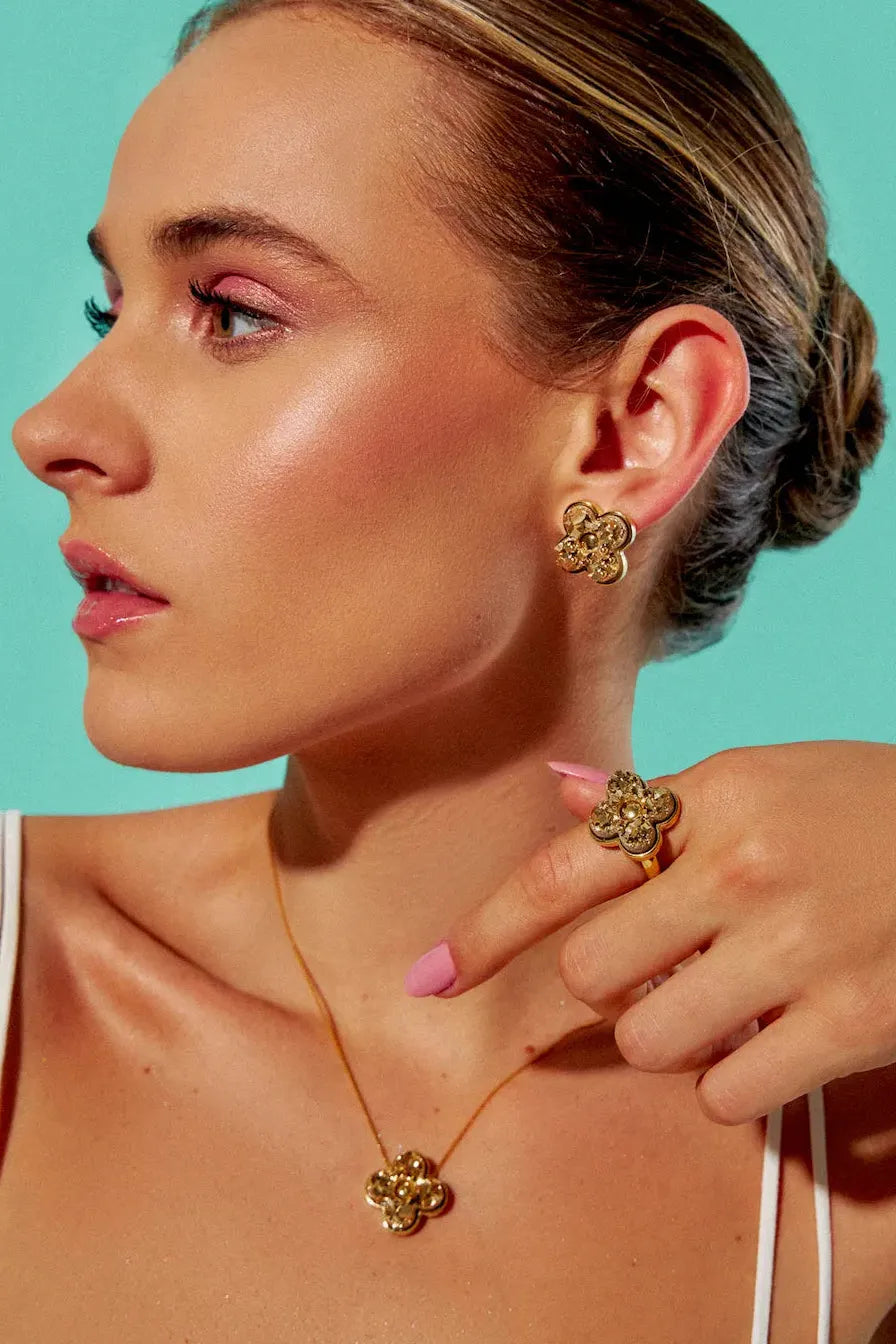 Este anel de design marcante é em Banho de Ouro 18K e apresenta Drusa Ouro, uma peça atemporal que reflete a sua essência e sofisticação.