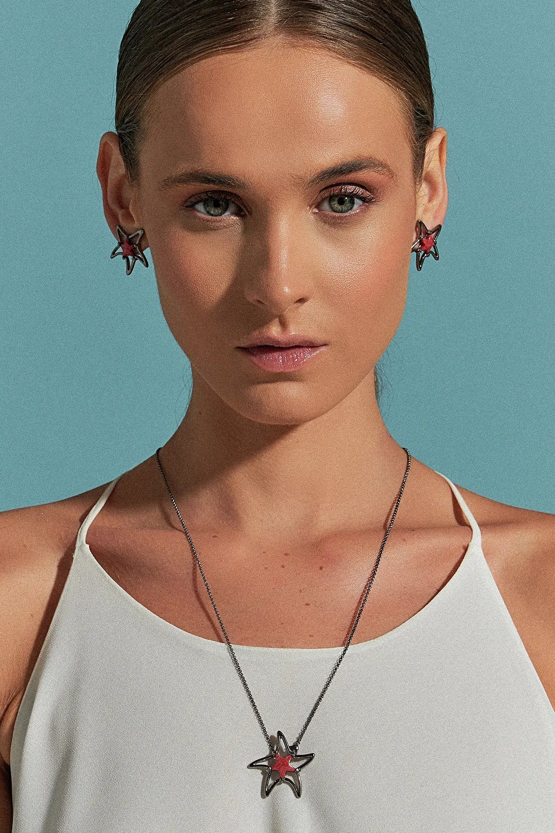 Use o Brinco Serena com Feldspato Vermelho em Banho de Ródio Negro, criando um visual moderno de alto contraste, ideal para atrair paixão e energia.