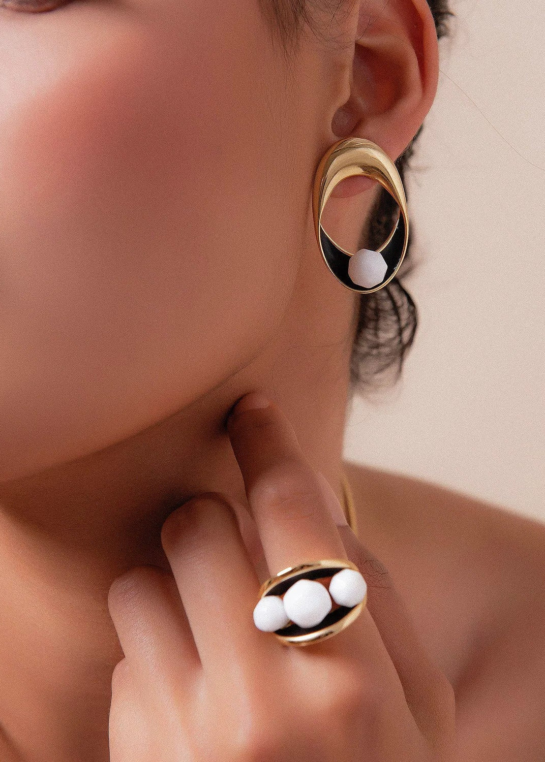 O Brinco Sinergia em Esmaltado Preto e Porcelana, com Banho de Ouro 18K, cria um visual de alto contraste e sofisticação. A combinação atemporal do branco da porcelana com o esmalte preto é realçada pelo brilho do ouro 18K.