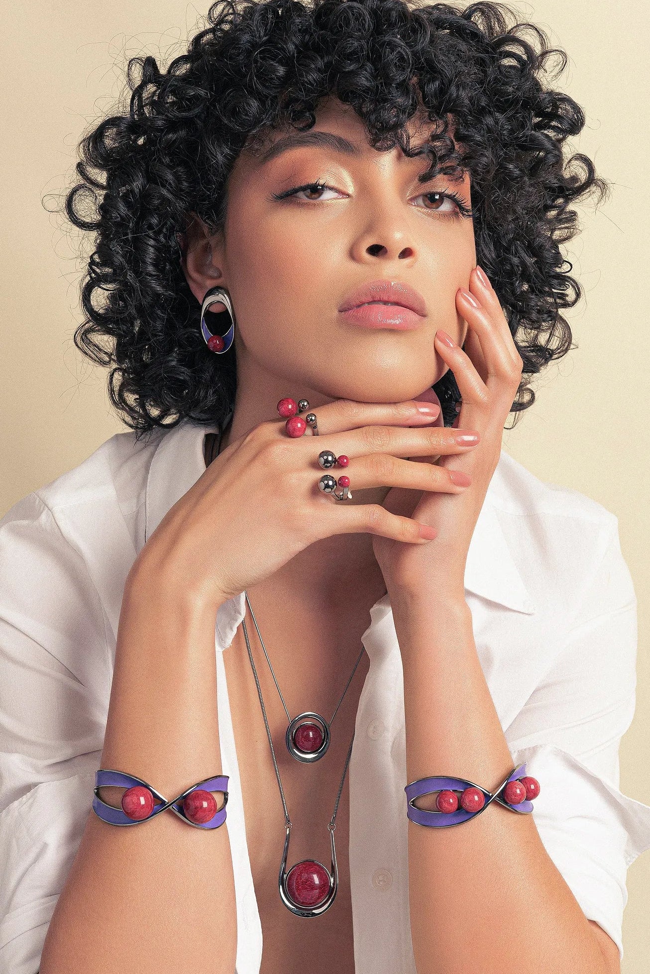 O Brinco Sinergia em Esmaltado Roxo e Feldspato Vermelho, com Banho de Ródio Negro, cria um visual de impacto. A combinação vibrante do vermelho com o roxo é realçada pelo luxuoso acabamento escuro do ródio negro.