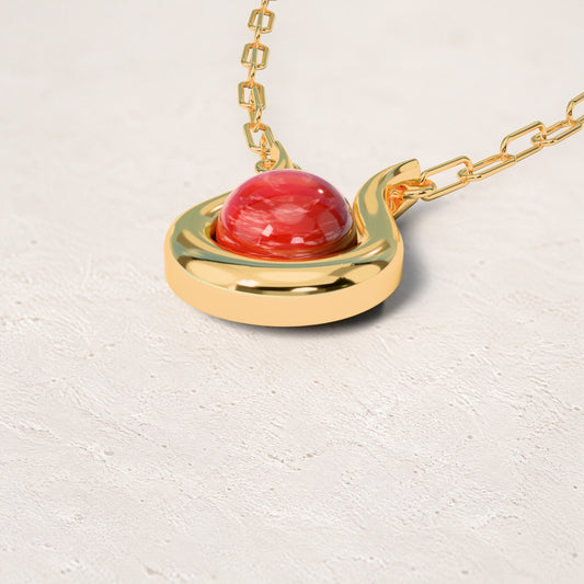 Colar Órbita - Feldspato Vermelho: sobre pedestal de gesso em forma de nuvem, fundo de céu azul-claro. Semijoia banhada a ouro 18k, coleção Supernova, Aimer Joias