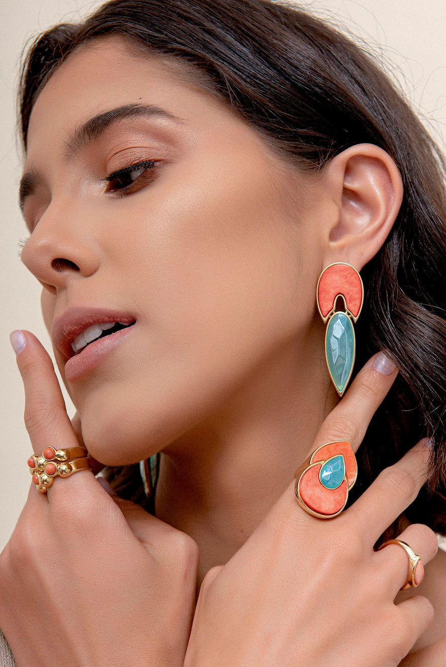 Esta joia combina cores que remetem ao sol e ao céu com o luxo do Banho de Ouro 18K. O anel é adornado com o Feldspato Laranja, que traz energia e vitalidade, e a Ágata Azul Céu, que oferece serenidade e paz interior.