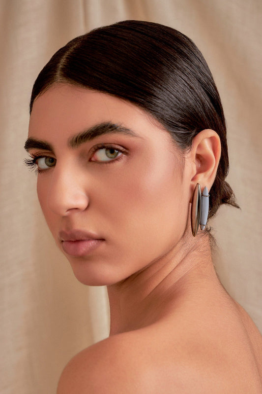 Use o Brinco Ecoa com Resina Azul Hortência em Banho de Ródio Negro para trazer calma e serenidade.