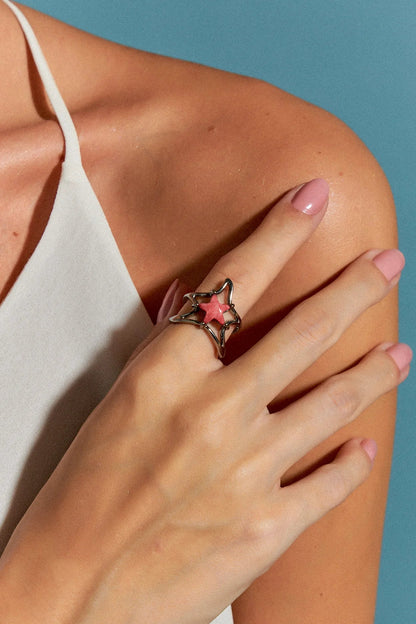 O Anel Brisa com Feldspato Vermelho em Banho de Ródio é uma joia delicada, com uma estrela central em meio a uma onda fluida que a sustenta. A cor intensa do Feldspato Vermelho, contrastada com o brilho metálico do Ródio, cria um visual marcante e sofisticado.
