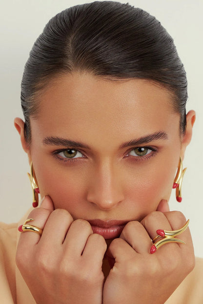 O Anel Caminhos com Feldspato Vermelho e Banho de Ouro 18K é uma joia de alto impacto. O tom vibrante e sedutor do Feldspato Vermelho Cabochão é realçado pelo brilho inconfundível do Ouro 18K, conferindo presença e poder a quem usa.