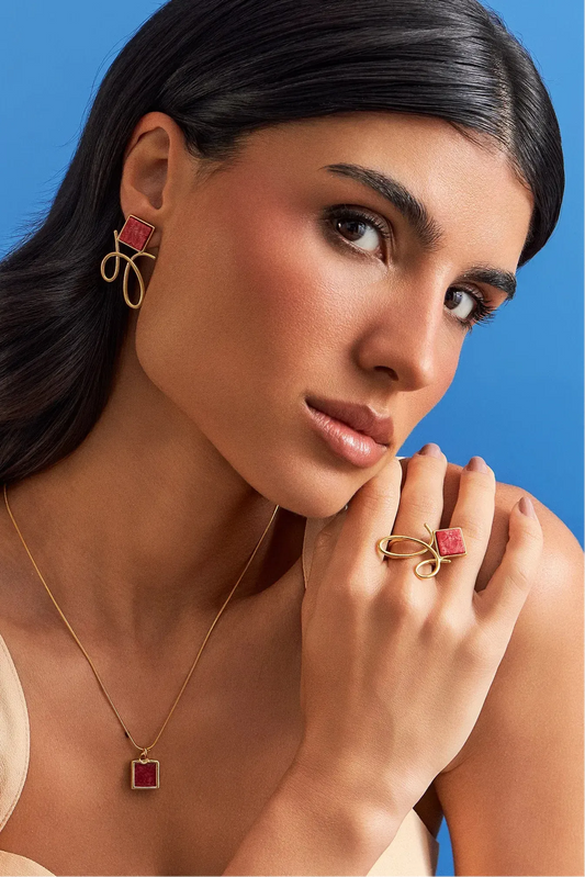 O Anel Esboço com Feldspato Vermelho em Banho de Ouro 18K traduz a união entre linhas e formas, em um desenho limpo e simbólico. A pedra quadrada de Feldspato Vermelho, que se equilibra de forma leve no traço orgânico da peça, simboliza energia e impulso. Sua estética combina o minimalismo da pedra com a fluidez do traço orgânico, garantindo um toque de modernidade e vitalidade à sua mão.