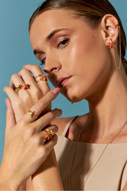 O Anel Estrela em Banho de Ouro 18K é uma pequena estrela-do-mar minimalista. Seu design delicado lembra a beleza serena encontrada nas profundezas do oceano, sendo uma peça versátil e essencial para adicionar um toque de luxo ao dia a dia.
