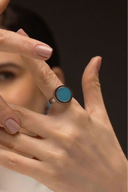 O Anel Eterno - Ágata Azul Céu, da Coleção Singular, une a serenidade das águas à sofisticação do acabamento escuro. A Ágata Azul Céu é reconhecida por promover calma, clareza mental e harmonia nas emoções, criando um contraste moderno e impactante com o metal escuro. Banhado a Ródio Negro, este anel de design contínuo e imponente destaca a suavidade da pedra, sendo a peça ideal para mulheres que buscam um acessório contemporâneo que transmita paz interior com uma personalidade forte.