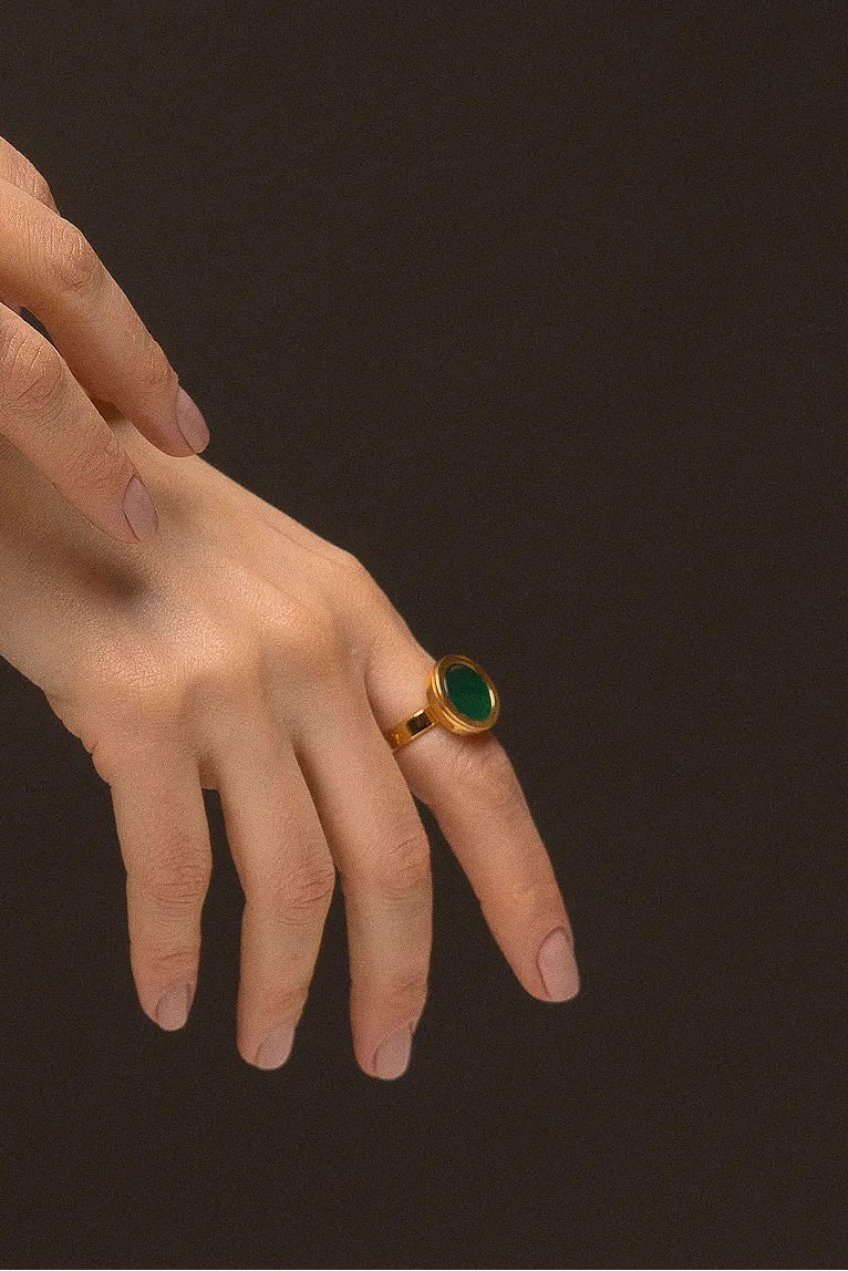 O Anel Eterno - Ágata Verde, da Coleção Singular, é uma joia que emana vitalidade e equilíbrio. A Ágata Verde é conhecida por ser a pedra da saúde, esperança e cura emocional, auxiliando na autoconfiança e no bem-estar físico. Banhado a Ouro 18K, este anel de design contínuo e imponente destaca a cor vibrante e a elegância atemporal da pedra, sendo a escolha ideal para quem busca uma conexão com a natureza e harmonia interna.