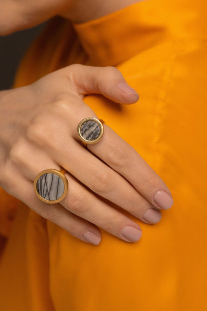 O Anel Eterno - Jaspe Net, integrante da Coleção Singular, é uma joia de beleza intrigante e visual moderno. O Jaspe Net, com suas ramificações naturais que lembram uma rede, é uma pedra associada ao equilíbrio, à proteção e ao fortalecimento da mente, auxiliando na organização dos pensamentos e na tomada de decisões. Banhado a Ouro 18K, este anel de design contínuo destaca os padrões orgânicos únicos da pedra, resultando em uma peça imponente e sofisticada para mulheres de estilo autêntico.