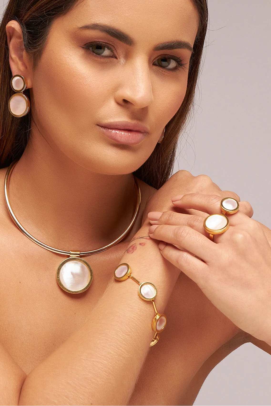 O Anel Eterno - Madrepérola Rosa, da Coleção Singular, é uma joia que exalta a delicadeza e o romantismo feminino. A Madrepérola Rosa é um elemento natural que simboliza amor, proteção maternal e intuição, apresentando uma iridescência suave que encanta ao refletir a luz. Banhado a Ouro 18K, este anel de design contínuo e imponente une a nobreza do metal dourado à ternura da gema, resultando em uma peça sofisticada, ideal para mulheres que buscam elegância com um toque de suavidade.