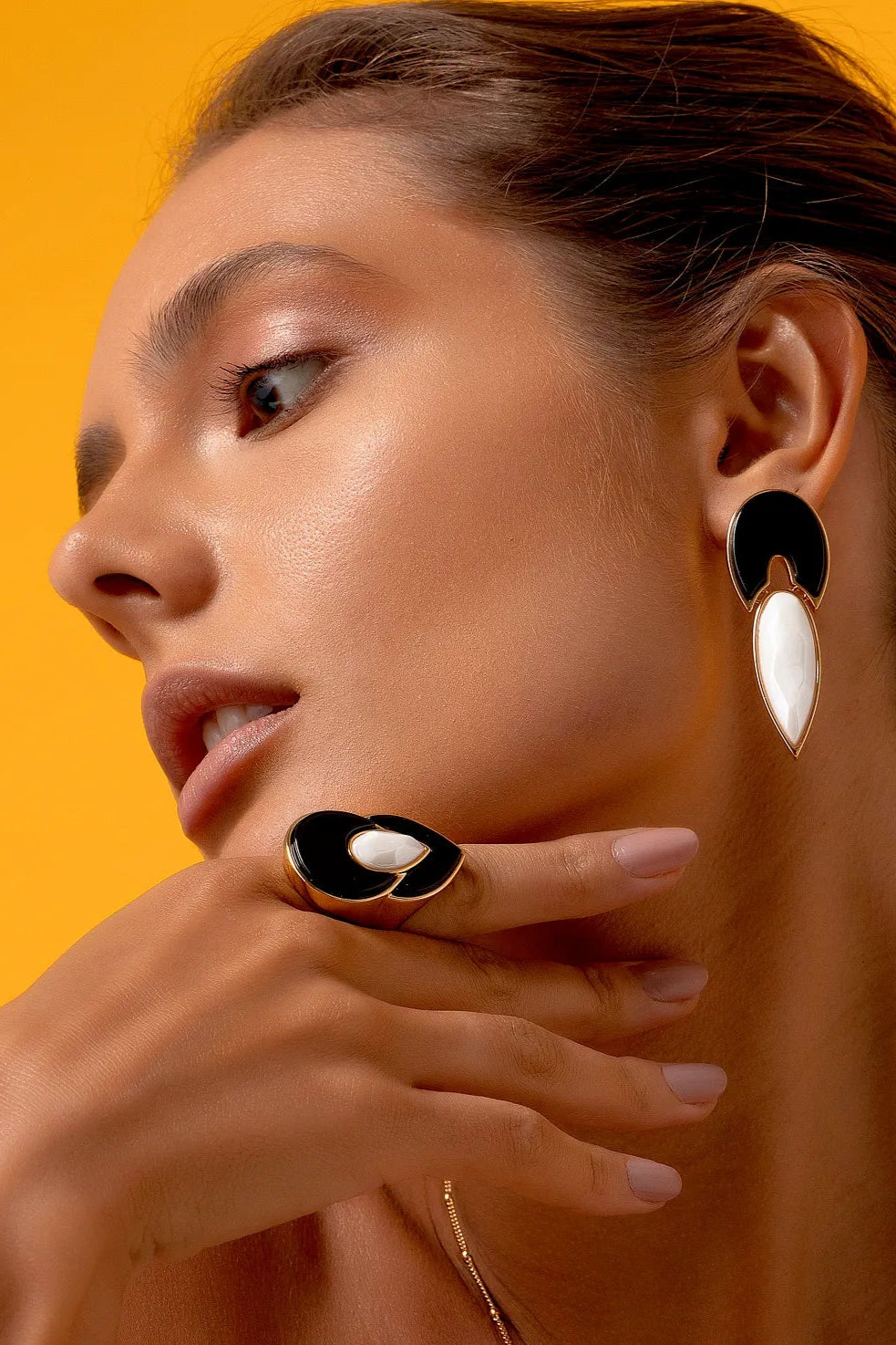 Esta joia apresenta um contraste atemporal de preto e branco, emoldurado pelo luxo do Banho de Ouro 18K. O anel é adornado com a Obsidiana, que oferece proteção e força, e a Porcelana, que adiciona um toque clássico e limpo ao design.