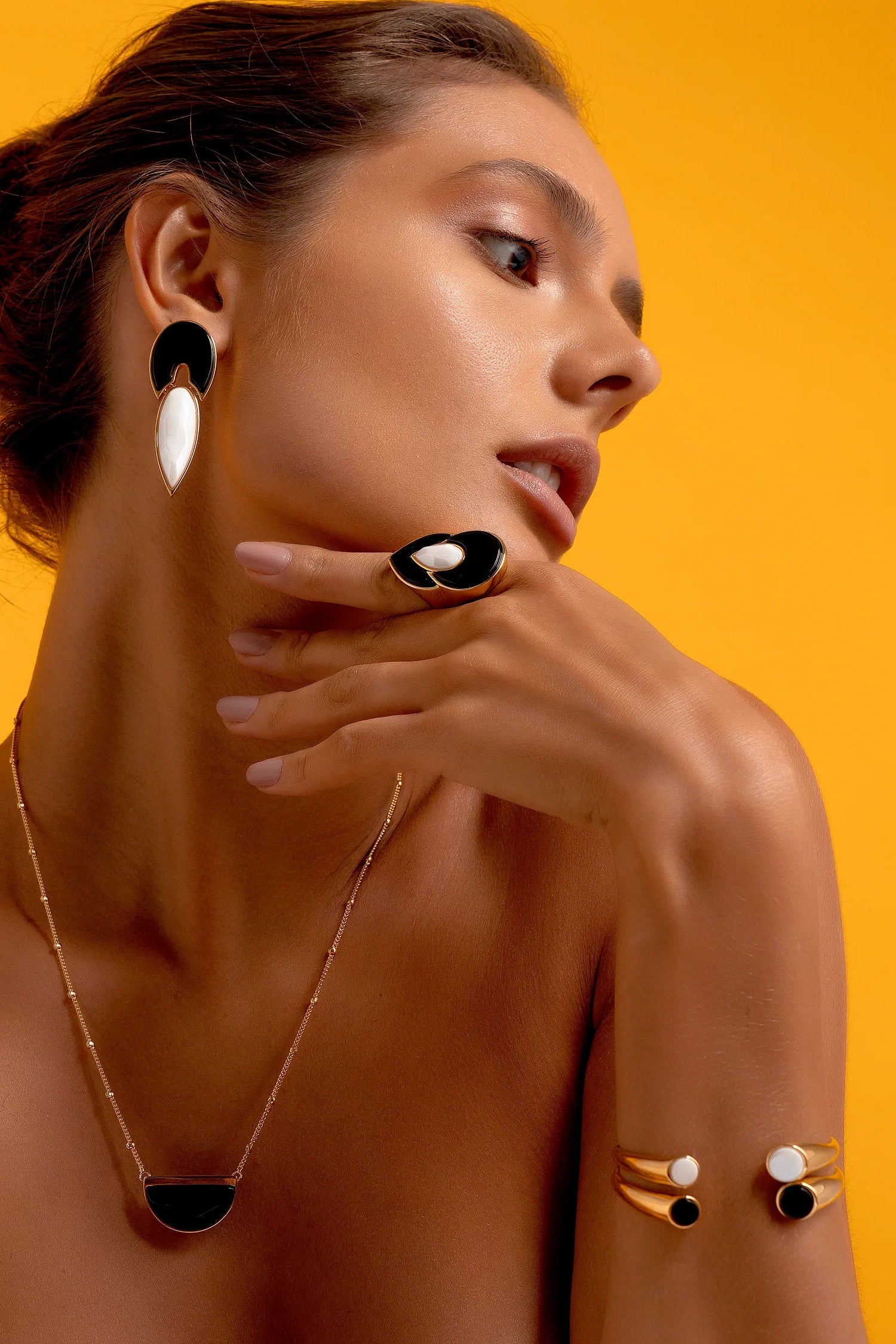 Esta joia apresenta um contraste atemporal de preto e branco, emoldurado pelo luxo do Banho de Ouro 18K. O anel é adornado com a Obsidiana, que oferece proteção e força, e a Porcelana, que adiciona um toque clássico e limpo ao design.