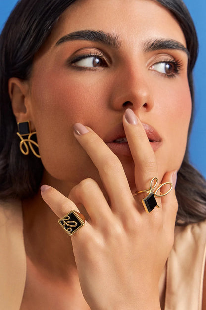 O Anel Forma com Obsidiana Negra em Banho de Ouro 18K é um anel de mindinho moderno, destacando a pedra com um arrojado metal sobreposto. A Obsidiana Negra simboliza força e proteção, tornando-o ideal para quem busca segurança e bloquear energias negativas. Com seu design contemporâneo de linhas em metal sobre a pedra, esta joia é perfeita para expressar elegância e personalidade no seu dia a dia.