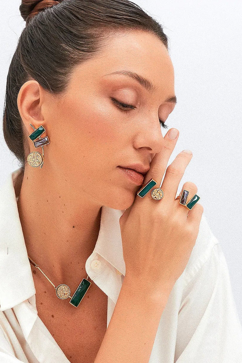 O Anel Harmonie - Ágata Verde e Quartzo Fumê, da Coleção Convicta, é uma joia projetada para a mulher moderna e multifacetada. Esta peça com banho de Ouro 18K e lapidação multifacetada une a vitalidade da Ágata Verde e a proteção do Quartzo Fumê. O anel é ideal para quem busca acessórios que combinem estilo sofisticado com bem-estar, ajudando a restaurar a força interior e neutralizar vibrações negativas.