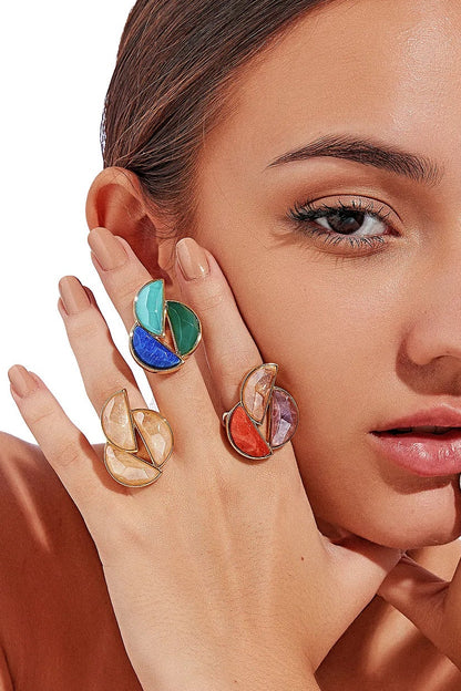 O Anel Impacto em Banho Ouro 18K une a energia de três cristais poderosos: o Citrino, para prosperidade e sucesso; a Ametista, para sabedoria e proteção espiritual; e o Feldspato Laranja, que atrai vitalidade e criatividade. Esta peça de design imponente combina o sucesso no amor, a prosperidade e a sabedoria em uma única joia.