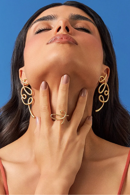 O Anel Rabiscos em Banho de Ouro 18K traduz a magia do risco que se arrisca a ser algo, com formas orgânicas e minimalistas. Este anel celebra a beleza do gesto livre e expressivo, sendo uma peça discreta, mas que carrega movimento e significado. É a essência da Coleção Entre o Traço e a Forma no seu dedo.