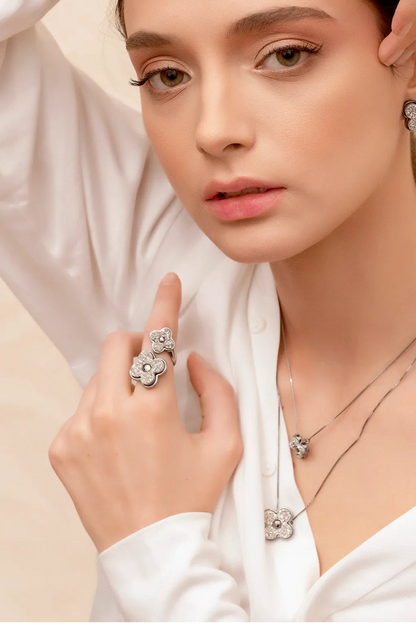 Este anel de design escultural é em Banho de Ródio Negro e apresenta Drusa Platina, uma pedra natural de superfície cintilante. O contraste da drusa em Prata com o banho escuro cria um visual luxuoso, moderno e de grande presença.