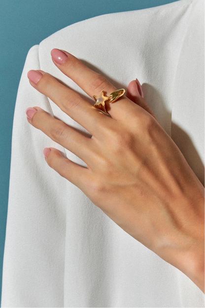 O Anel Serena com Ágata Branca em Banho de Ouro 18K apresenta uma suave onda que vai de encontro com a estrela-do-mar, formando um elo entre elas. A pureza da Ágata Branca é realçada pelo luxo do ouro, criando um visual delicado, elegante e que evoca a serenidade do oceano.