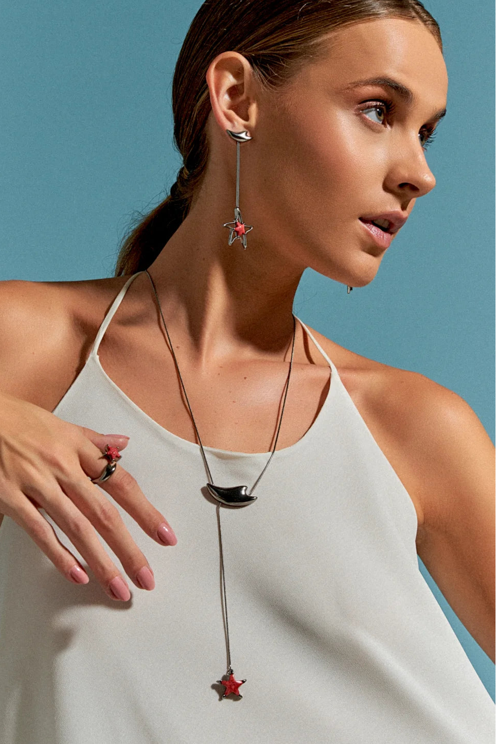 O Anel Serena com Feldspato Vermelho em Banho de Ródio Negro possui duas estrelas-do-mar que se encontram na mesma direção, simbolizando harmonia e união. A cor intensa do Feldspato Vermelho, em contraste com o brilho escuro e metálico do Ródio Negro, cria um visual sofisticado e marcante.