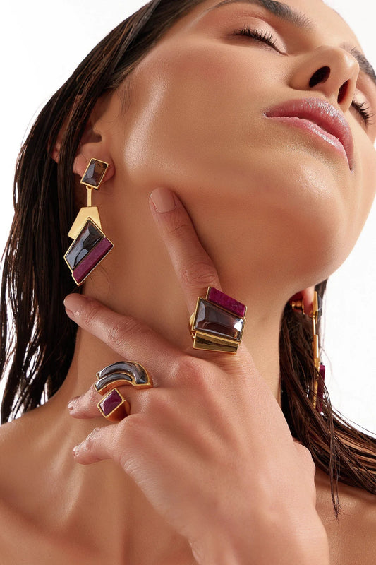 O Anel Strelitzia em Banho Ouro 18K une a força protetora do Quartzo Fumê à doçura do Feldspato Rosa Pink, promovendo proteção, autoestima e cura emocional. Esta joia exuberante reflete a elegância e o poder interior, transformando energias com sofisticação.