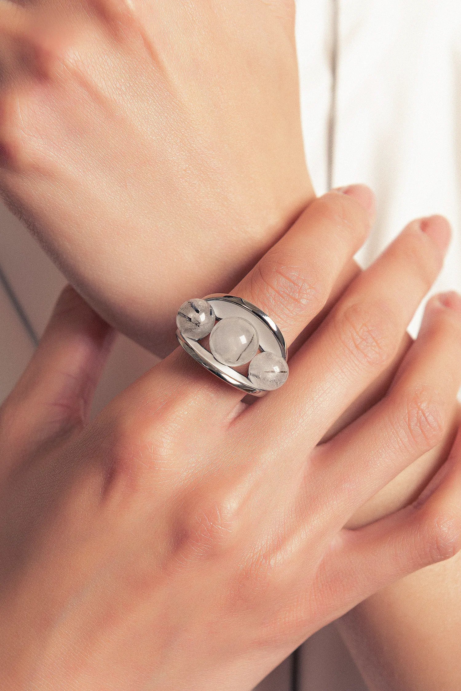 O Anel Sublime em Esmaltado Branco e Quartzo Grafitado, com Banho de Ouro 18K, é uma peça de contraste clássico e sofisticado. O Quartzo Grafitado Liso harmoniza-se com o esmalte branco, criando um visual elegante e atemporal com o brilho do ouro.