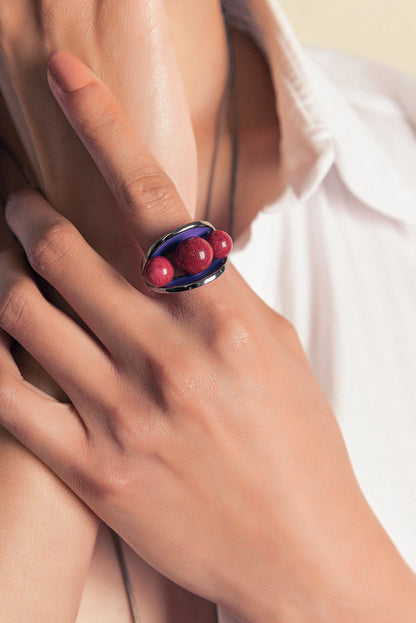 O Anel Sublime em Esmaltado Roxo e Feldspato Vermelho, com Banho de Ouro 18K, é uma peça de contraste elegante e marcante. O Feldspato Vermelho Liso harmoniza-se com o esmalte em tom roxo, criando um visual sofisticado que contrasta com o brilho do ouro.