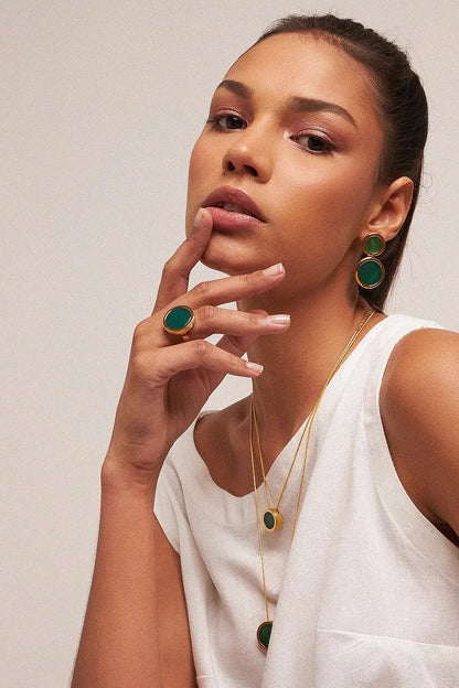 O Anel Único - Ágata Verde, da Coleção Singular, é uma joia que emana vitalidade e equilíbrio. A Ágata Verde é conhecida por ser a pedra da saúde, esperança e cura emocional, auxiliando na autoconfiança e no bem-estar físico. Banhado a Ouro 18K, este anel de design imponente destaca a cor vibrante e a elegância atemporal da pedra, sendo a escolha ideal para quem busca uma conexão com a natureza e harmonia interna.