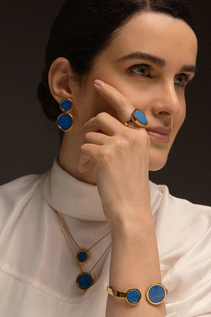 O Anel Único - Feldspato Azul Anil faz parte da Coleção Singular, que destaca a exclusividade e o valor individual de cada mulher. O Feldspato Azul Anil é uma pedra que favorece a intuição, a autoconfiança e a clareza mental. Com um design imponente e banhado a Ouro 18K, esta joia transforma a simplicidade em uma peça magnífica, perfeita para quem deseja expressar sua força com elegância e serenidade.