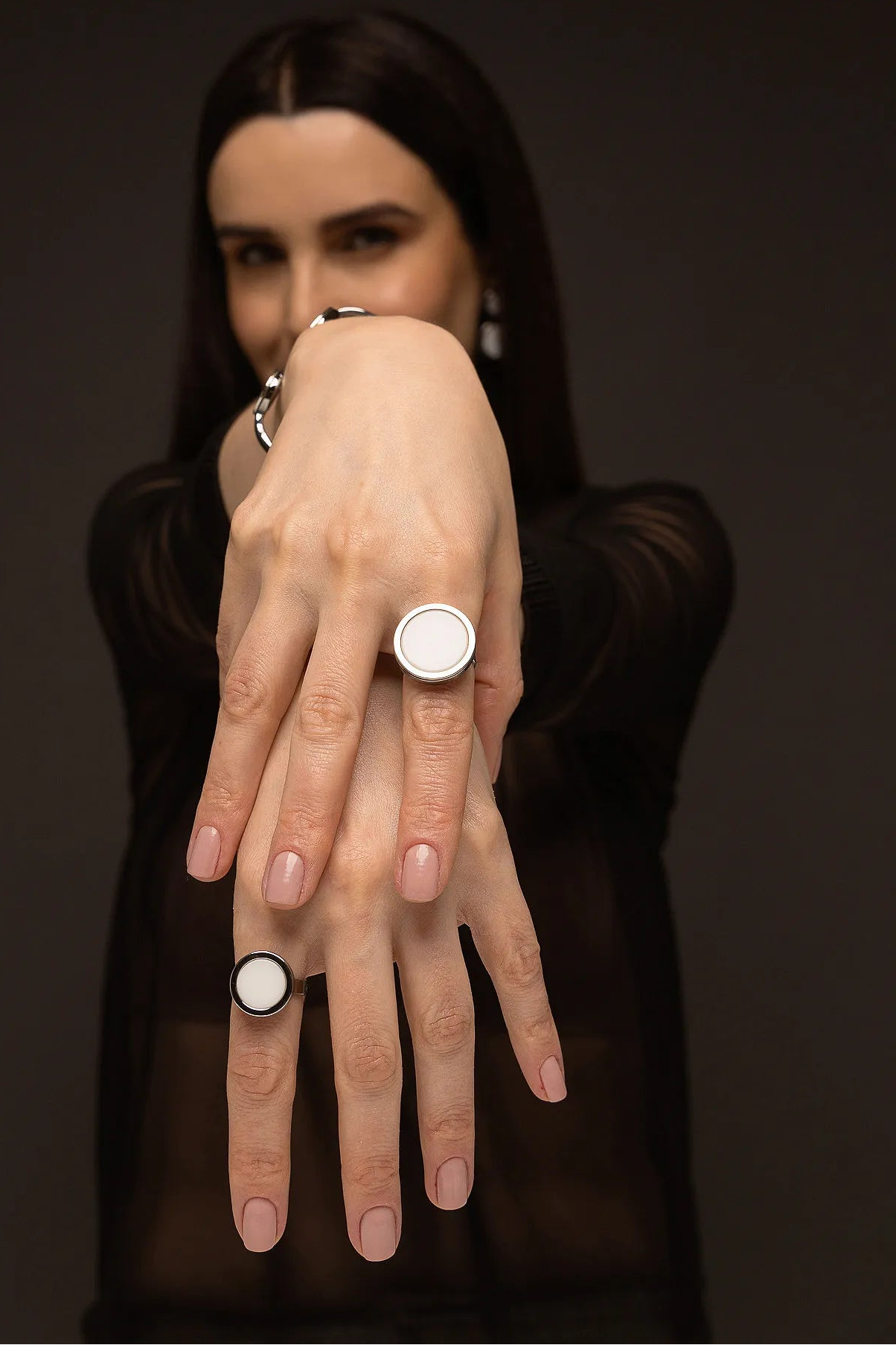 O Anel Único - Porcelana Branca, da Coleção Singular, une a pureza do branco ao mistério do acabamento escuro. A Porcelana Branca simboliza renovação, clareza e paz interior, criando um contraste moderno e sofisticado com o metal escuro. Banhado a Ródio Negro, este anel de design imponente destaca o brilho suave da pedra lisa, sendo a peça ideal para mulheres que buscam acessórios contemporâneos que transmitem serenidade com uma personalidade marcante.