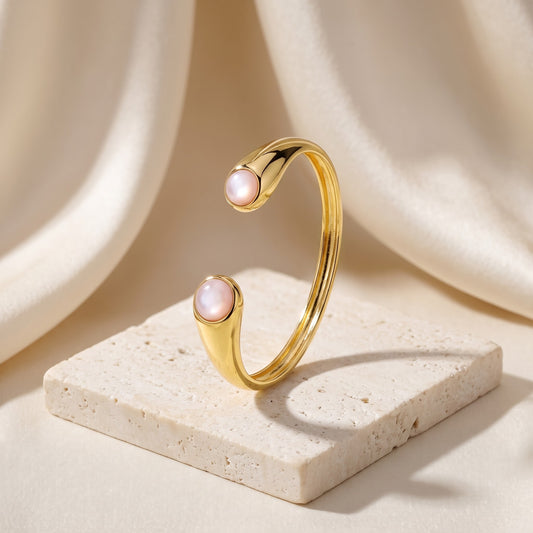 Bracelete Pocket Ball Madrepérola banhado a ouro 18k em vista 3/4 sobre travertino | Aimer Joias