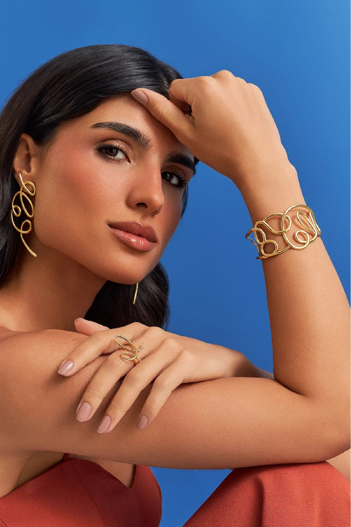 O Bracelete Traços em Banho de Ouro 18K é rígido e de aro aberto, trazendo o mesmo design de linhas livres do brinco, como um desenho contínuo que abraça o pulso. É um lembrete de que o belo não nasce do controle absoluto, mas do gesto que ousa sair do traço e encontra uma nova forma de ser. Peça expressiva e moderna, que incorpora movimento e fluidez.