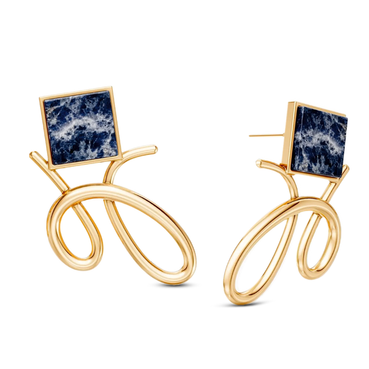 O Brinco Esboço com Sodalita em Banho de Ouro 18K traduz o instante em que o traço encontra a forma. Este brinco pequeno e delicado une a pedra quadrada, que atua como ponto de luz, a um toque sutil de traço. A Sodalita simboliza clareza e intuição. Com sua geometria precisa e o contraste sutil das linhas em metal, esta peça é perfeita para quem busca expressar sofisticação e leveza, elevando o visual com um toque contemporâneo.