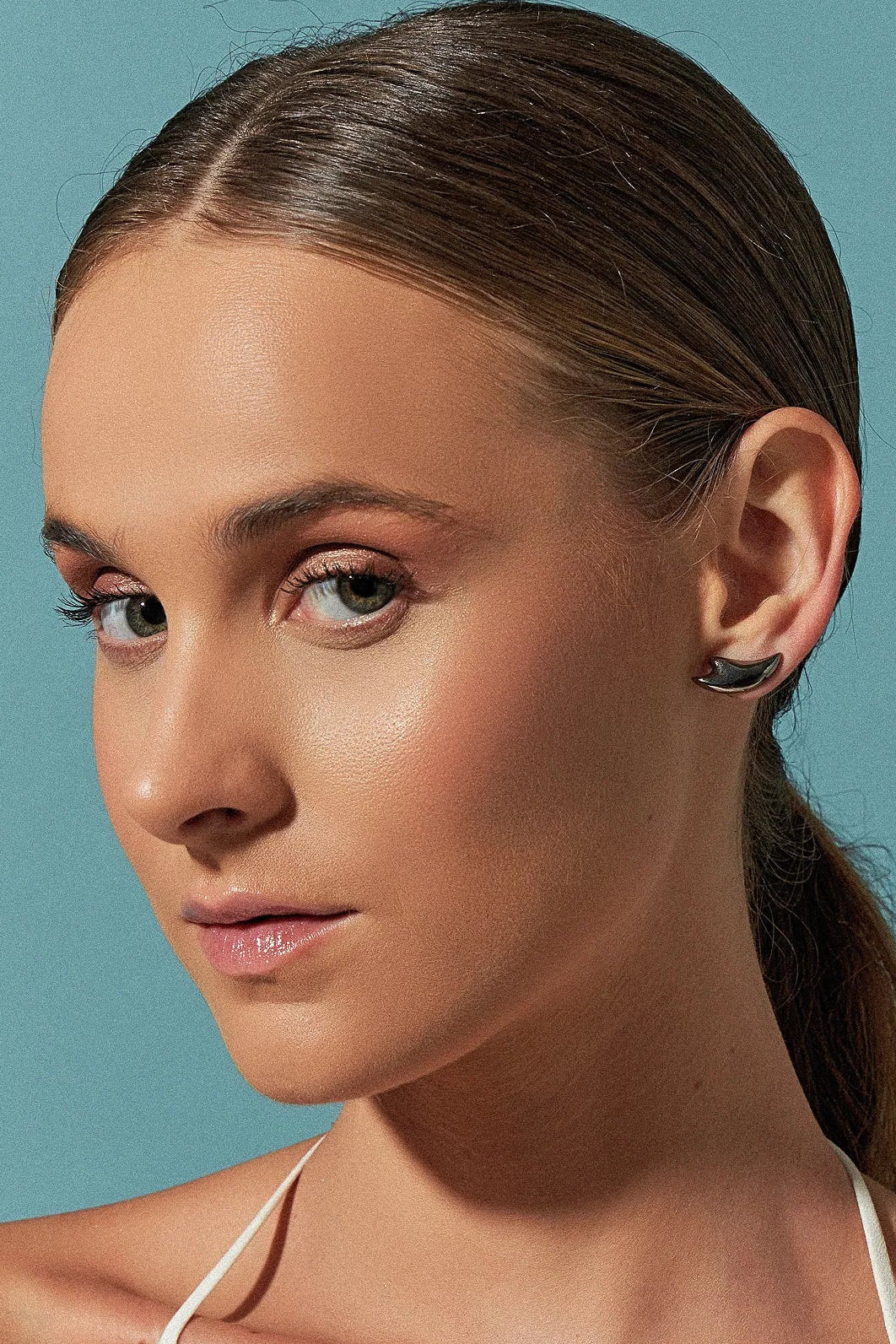 Use o Brinco Brisa com Feldspato Vermelho em Banho de Ródio Negro, criando um contraste dramático e luxuoso entre o tom vibrante da pedra e o acabamento escuro e moderno do ródio.