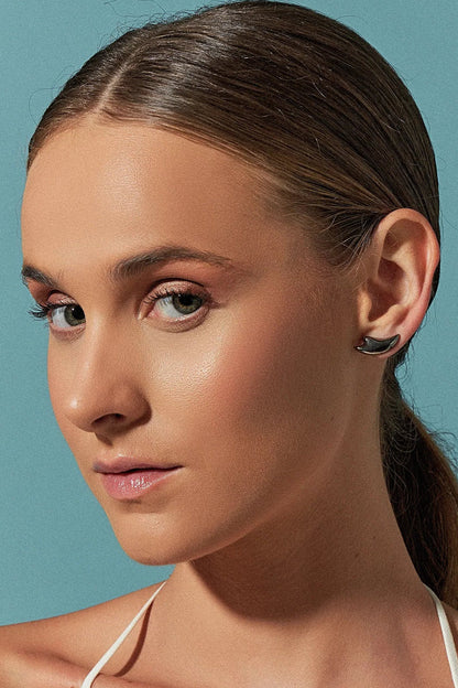 Use o Brinco Brisa com Feldspato Vermelho em Banho de Ródio Negro, criando um contraste dramático e luxuoso entre o tom vibrante da pedra e o acabamento escuro e moderno do ródio.