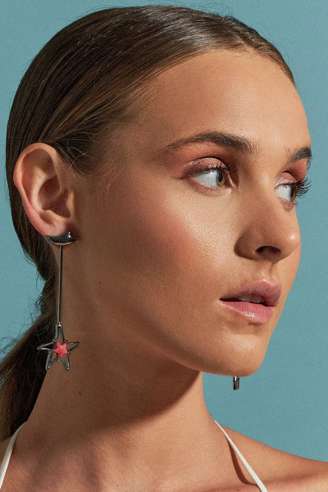 Use o Brinco Brisa com Feldspato Vermelho em Banho de Ródio Negro, criando um contraste dramático e luxuoso entre o tom vibrante da pedra e o acabamento escuro e moderno do ródio.